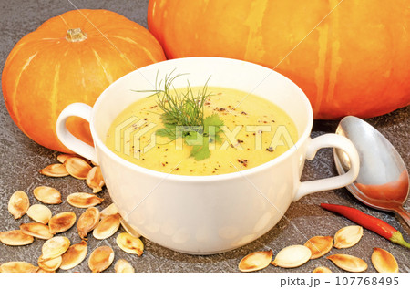 Pumpkin hot puree soup on a wooden table Pumpkin hot puree soup on a wooden table 107768495