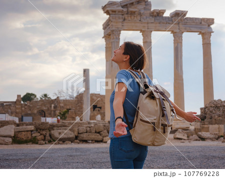 travel to ancient city of Side, Antalya coast of Turkey in tourist low season. Young tourist Asian woman is posing in front of temple of Apollo 107769228