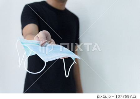 Man hand's holding medical protective mask 107769712