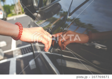 Close up of a woman opens car's door. 107769871