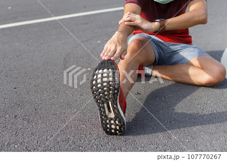man in medical protective mask. He warm up before running.workout concept 107770267
