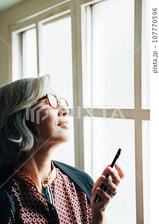 空を見上げるシニア女性 107770596