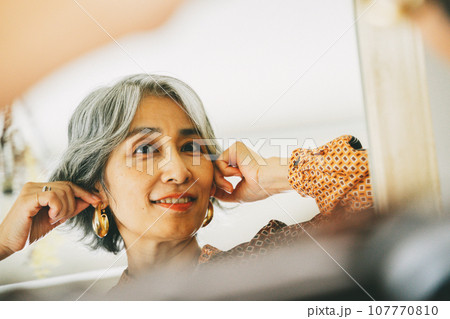 鏡を見ながら身支度をするシニア女性 鏡を見ながら身支度をするシニア女性 107770810