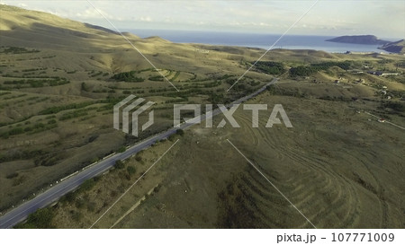 Desert road, Aerial footage. Shot. Desert and the road surrounded by sea aerial view Desert road, Aerial footage. Shot. Desert and the road surrounded by sea aerial view 107771009