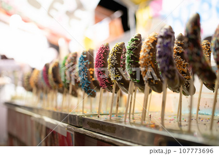 沢山並んだカラフルなチョコバナナ 107773696