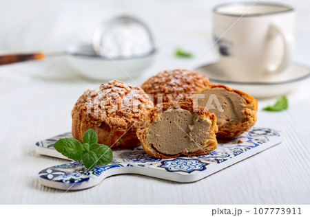Custard cakes (choux) with coffee cream. 107773911