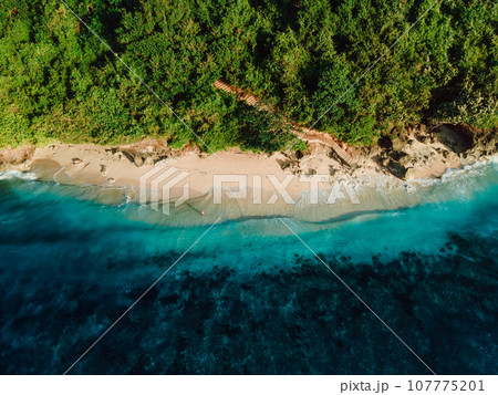 Tropical beach with blue ocean in Bali. Aerial view of Green bowl beach 107775201