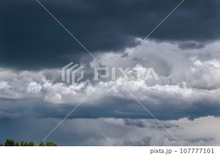 Gray white clouds. Clouds of thunderclouds on a blue sky. Summer day. Beautiful nature background Gray white clouds. Clouds of thunderclouds on a blue sky. Summer day. Beautiful nature background 107777101
