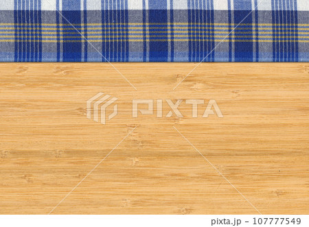 Blue white plaid napkin on bamboo wooden floor table or cutting board Blue white plaid napkin on bamboo wooden floor table or cutting board 107777549
