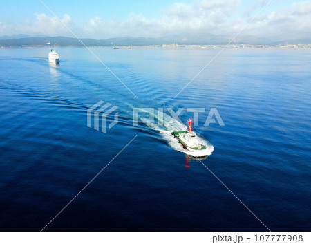 秋の北海道函館市函館港に寄港するクルーズ船の水先案内をするタグボートの風景を撮影 107777908