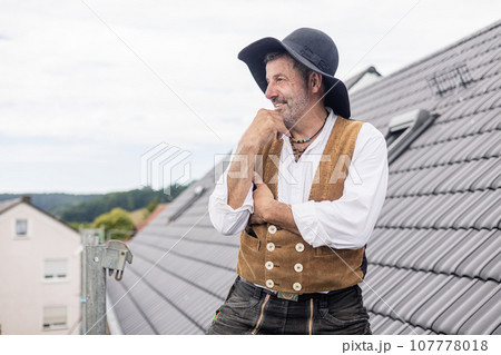 Proud Roofer standing on roof of home Proud Roofer standing on roof of home 107778018