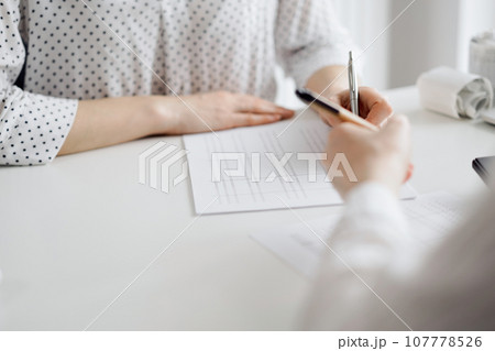 Two accountants using a laptop computer and calculator for counting taxes at white desk in office. Teamwork in business audit and finance Two accountants using a laptop computer and calculator for counting taxes at white desk in office. Teamwork in business audit and finance 107778526