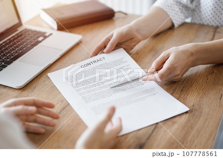 Businesswoman lawyer pointing into contract special points admitting something for colleague or client at the wooden desk in office. Business people teamwork and partnership, meeting concept Businesswoman lawyer pointing into contract special points admitting something for colleague or client at the wooden desk in office. Business people teamwork and partnership, meeting concept 107778561