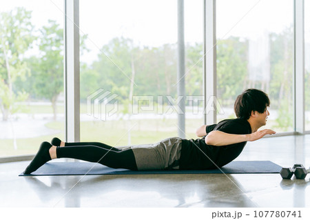 上体反らしをする若い男性（背筋・筋トレ・バックエクステンション・自重トレーニング） 107780741