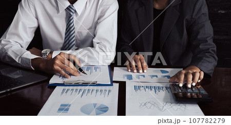 businessmen and businesswomen team meeting to plan strategies to increase business income. Have a brainstorming graph analysis and discussing for the new target success 107782279