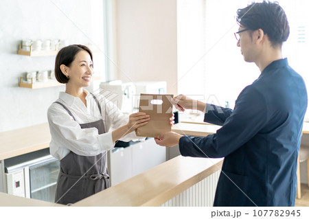 カフェで働く女性　テイクアウト　お持ち帰り 107782945