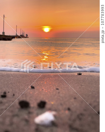 夕日が沈む海 107783993