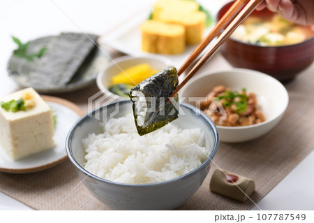 和食の朝ごはん 焼き海苔を箸でつかむ(朝食イメージ)納豆、味噌汁 卵焼き めざし 漬物 日本食 和食の朝ごはん 焼き海苔を箸でつかむ(朝食イメージ)納豆、味噌汁 卵焼き めざし 漬物 日本食 107787549