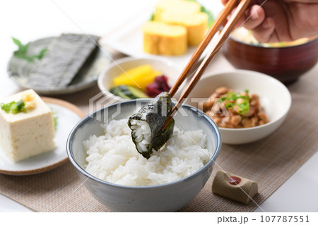 和食の朝ごはん 焼き海苔を箸でつかむ（朝食イメージ）納豆、味噌汁 卵焼き めざし 漬物 日本食 107787551
