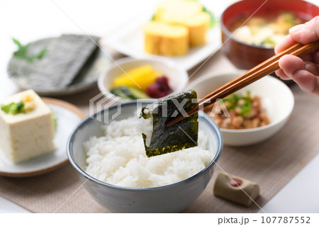 和食の朝ごはん 焼き海苔を箸でつかむ(朝食イメージ)納豆、味噌汁 卵焼き めざし 漬物 日本食 和食の朝ごはん 焼き海苔を箸でつかむ(朝食イメージ)納豆、味噌汁 卵焼き めざし 漬物 日本食 107787552