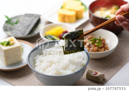 和食の朝ごはん 焼き海苔を箸でつかむ(朝食イメージ)納豆、味噌汁 卵焼き めざし 漬物 日本食 和食の朝ごはん 焼き海苔を箸でつかむ(朝食イメージ)納豆、味噌汁 卵焼き めざし 漬物 日本食 107787553