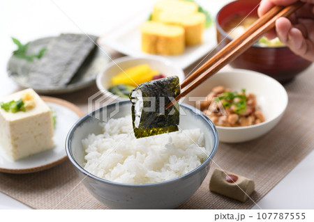和食の朝ごはん 焼き海苔を箸でつかむ（朝食イメージ）納豆、味噌汁 卵焼き めざし 漬物 日本食 107787555