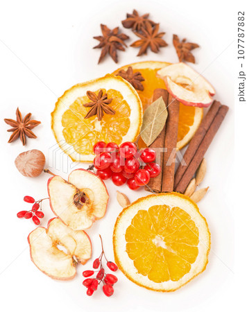 Christmas spices - cinnamon, anise, nuts, apples and dried orange slices 107787882