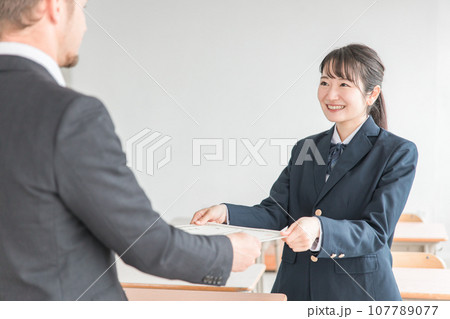 卒業式に卒業証書を渡す先生と受け取る生徒（女子高生・高校生・中学生） 107789077