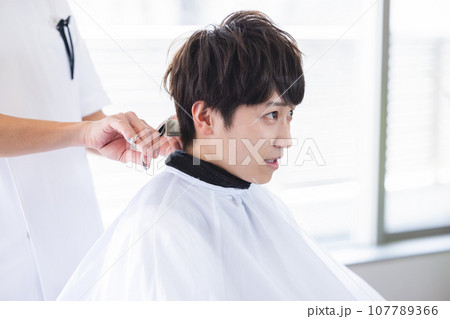 美容室で髪をカットする男性 107789366