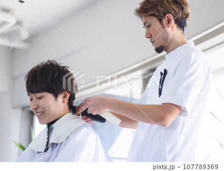 美容室で髪をカットする男性 107789369