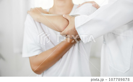Female physiotherapists provide assistance to male patients with elbow injuries and examine patients in rehabilitation centers. Physiotherapy concepts 107789878
