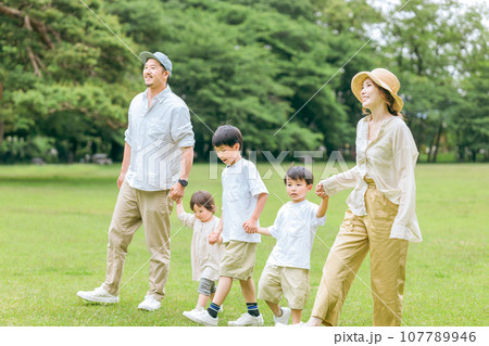 夏休みに公園を手を繋いで歩く家族・ファミリー（レジャー・アウトドア・ピクニック・キャンプ・思い出） 107789946