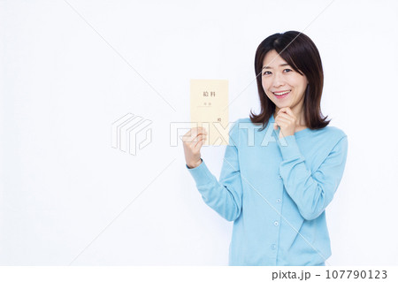 白い背景の前で給料袋を持って笑顔で考えている30代の女性 白い背景の前で給料袋を持って笑顔で考えている30代の女性 107790123