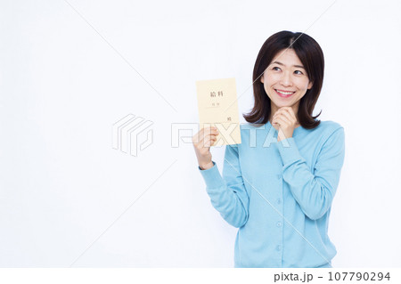 白い背景の前で給料袋を持って笑顔で考えている30代の女性 白い背景の前で給料袋を持って笑顔で考えている30代の女性 107790294