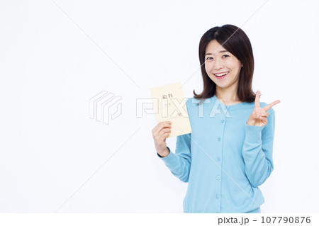白い背景の前で給料袋を持ってピースサインをしている30代の女性 107790876