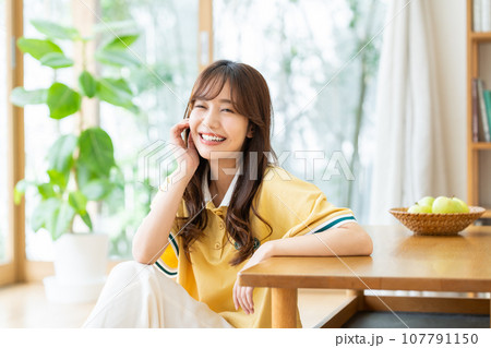 リビングでくつろぐ若い女性 リビングでくつろぐ若い女性 107791150