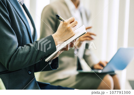 打ち合わせ・商談でメモをとる女性 打ち合わせ・商談でメモをとる女性 107791300