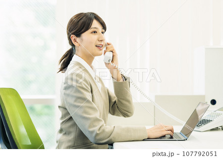 オフィスで電話対応する女性 オフィスで電話対応する女性 107792051
