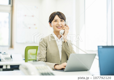 オフィスで電話対応する女性 107792120