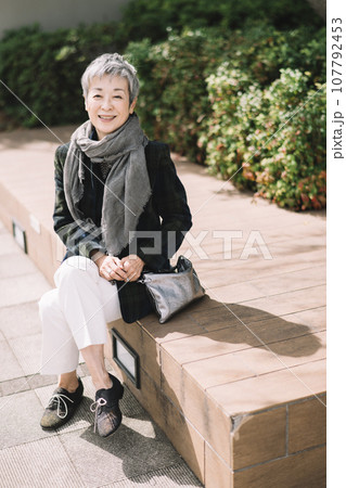 街角に座るグレイヘアの上品な日本人女性・ビジネスウーマン 街角に座るグレイヘアの上品な日本人女性・ビジネスウーマン 107792453