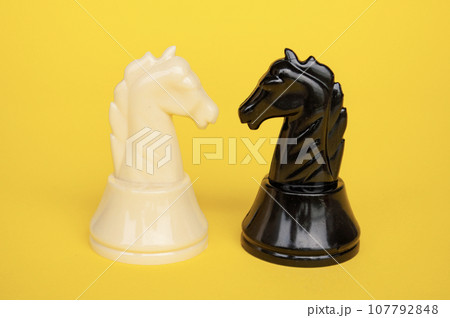 Selective view of knight chess moving toward for battle with yellow cover background. Strategy and tactic concept 107792848