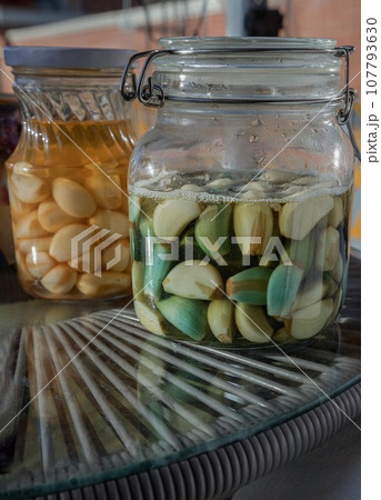 Glass jars with Garlic pickled in Apple cider vinegar with Rock sugar. Healthy pickled garlic. Glass jars with Garlic pickled in Apple cider vinegar with Rock sugar. Healthy pickled garlic. 107793630