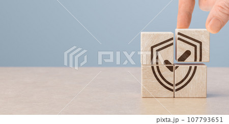 Protection health and life insurance concept. Care for employees. Hand puts wooden cubes with shield protect and tick mark. copy space. 107793651
