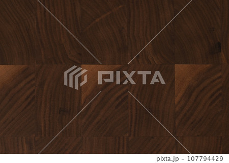 Black walnut end grain wood cutting board texture with oil finish closeup 107794429