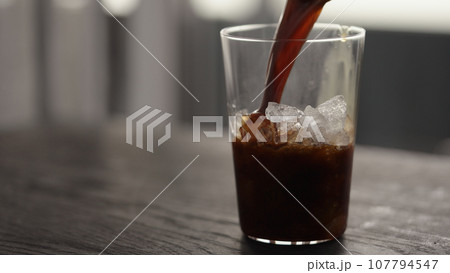 Making espresso tonic in tumbler glass, pour espresso in glass with crushed ice 107794547