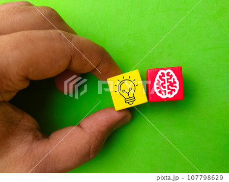Hand holding colored cubes with bulb and brain icons. the concept of innovation 107798629