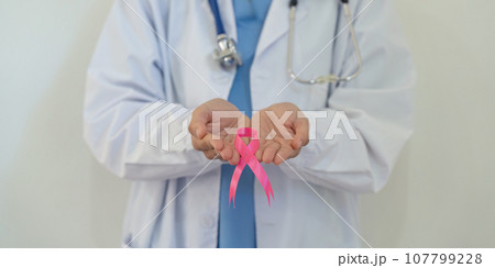 Pink October Breast Cancer Awareness month, doctor with pink ribbon symbol. National cancer survivors month. health care concept Pink October Breast Cancer Awareness month, doctor with pink ribbon symbol. National cancer survivors month. health care concept 107799228