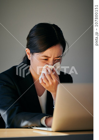 ティッシュで鼻を押さえる若い女性 107800151