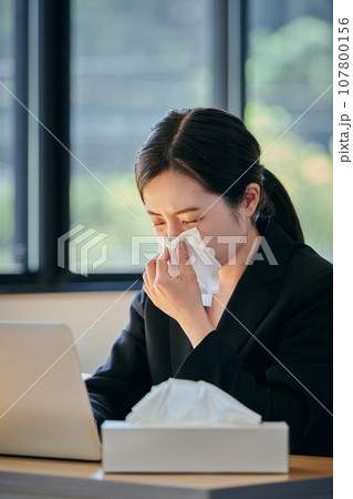 ティッシュで鼻を押さえる若い女性 ティッシュで鼻を押さえる若い女性 107800156