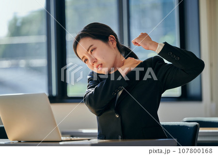 デスクワークで肩がこる若い女性 デスクワークで肩がこる若い女性 107800168